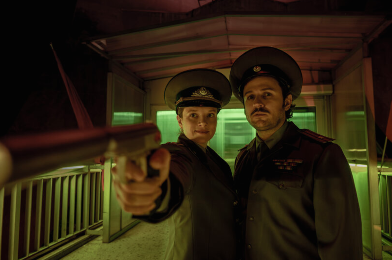 KLEO pointing a gun In the camera