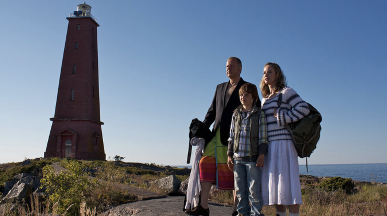 Wernher and his family standing at the coast next to to a lighthouse